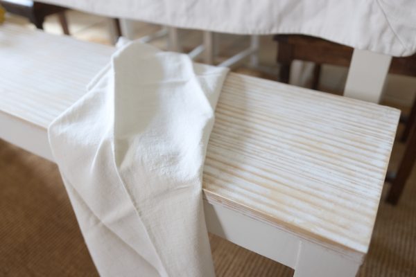 Bancs restaurés en bois et blanc, esprit shabby, avec un torchon ancien dessus. Veinage du bois