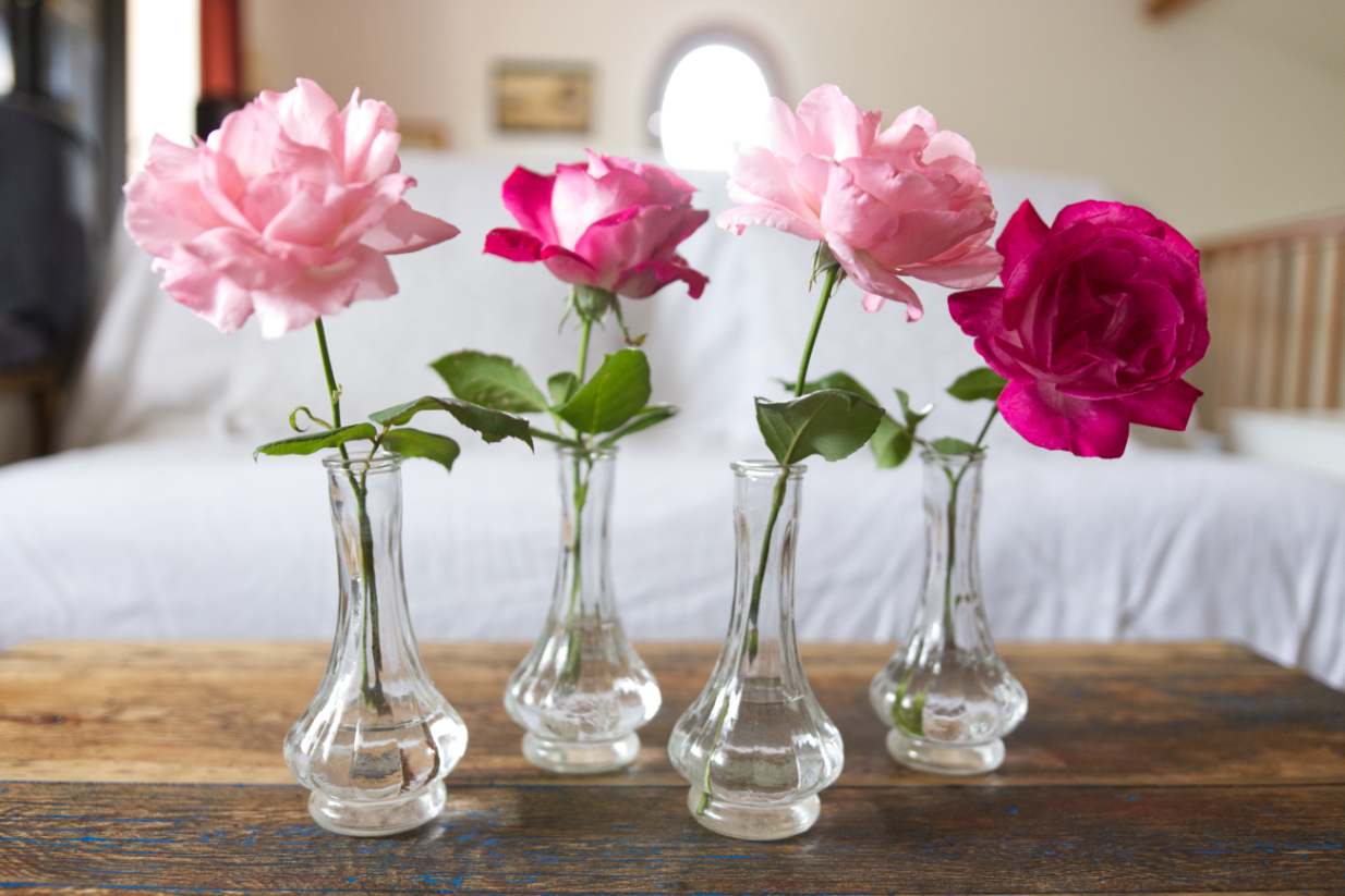 Soliflores, vases vintages hauts et canelés avec des roses dedans